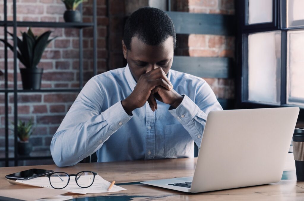 An African-American man in a blue dress shirt uses an AI test for depression.