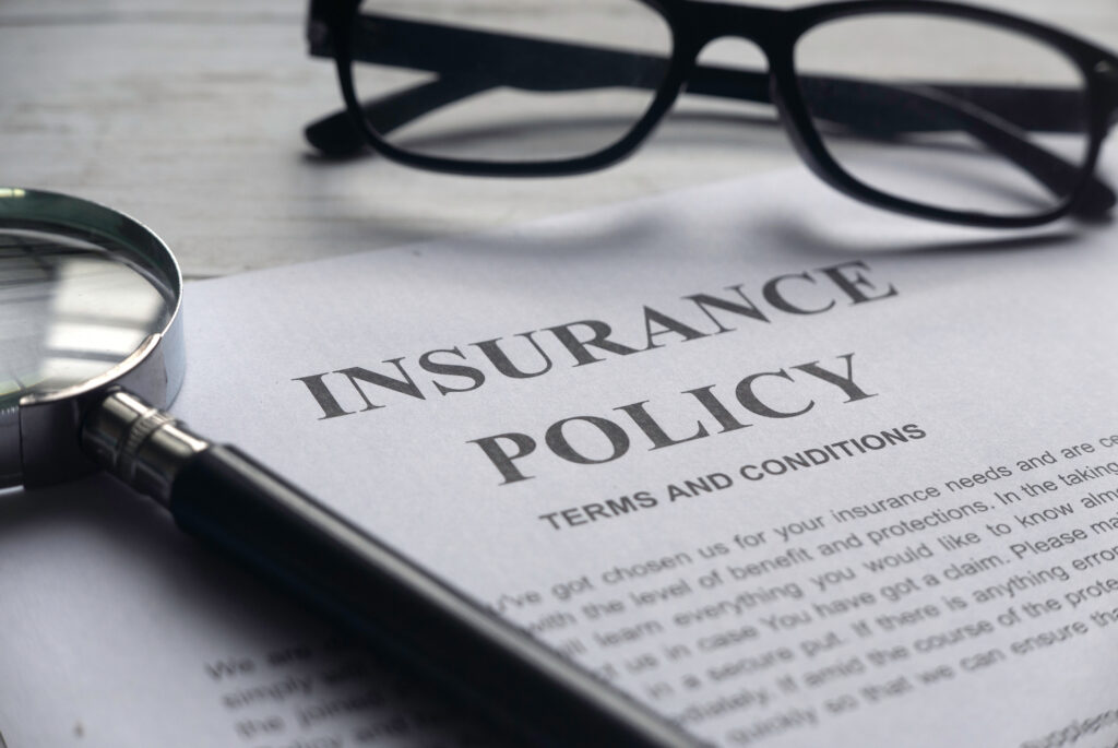 An insurance policy with glasses and a magnifying glass