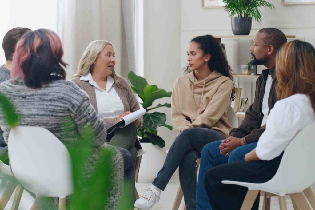 Group therapy session for addiction treatment with therapist leading discussion