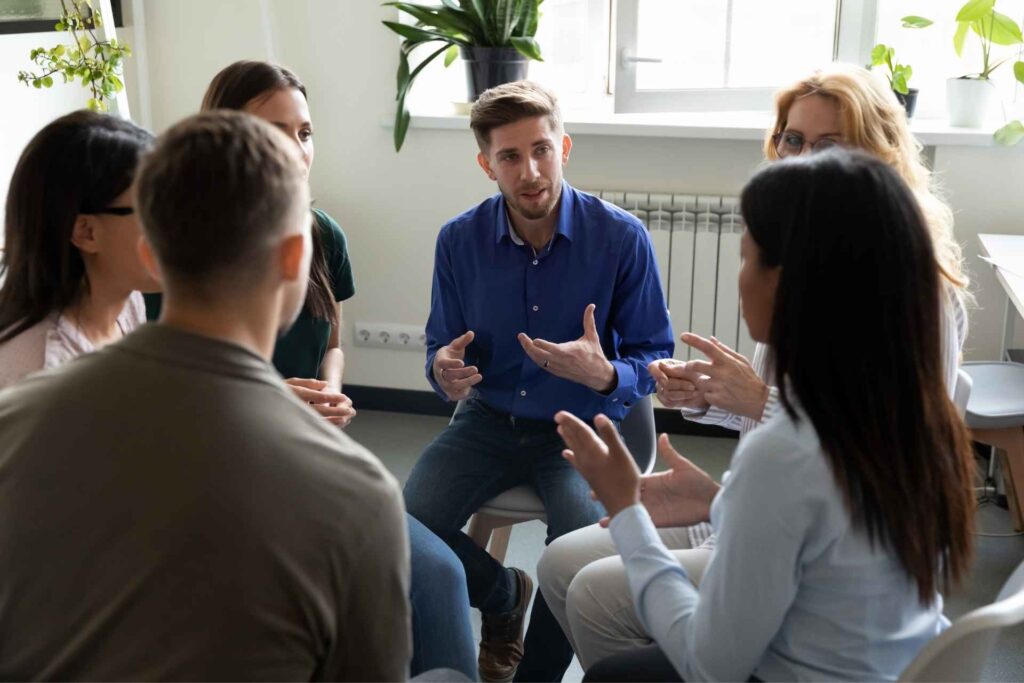 Adults participating in a dual-diagnosis group therapy session at an outpatient addiction treatment program.
