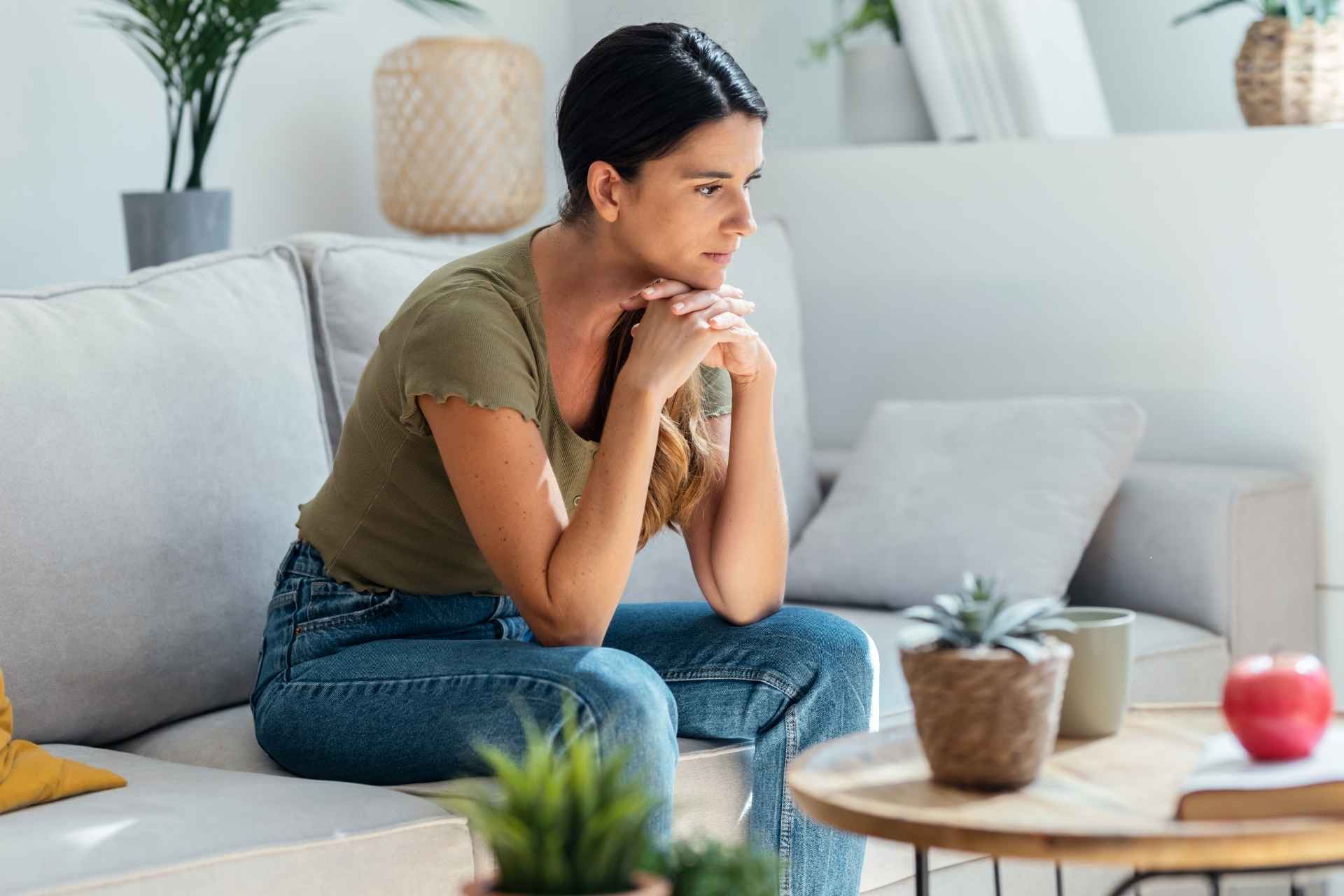 Woman reflecting at home while continuing her recovery journey after completing addiction treatment.