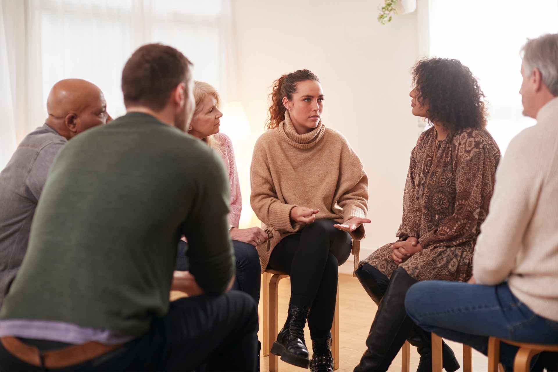 Adults participating in a dual-diagnosis group therapy session during outpatient addiction treatment.