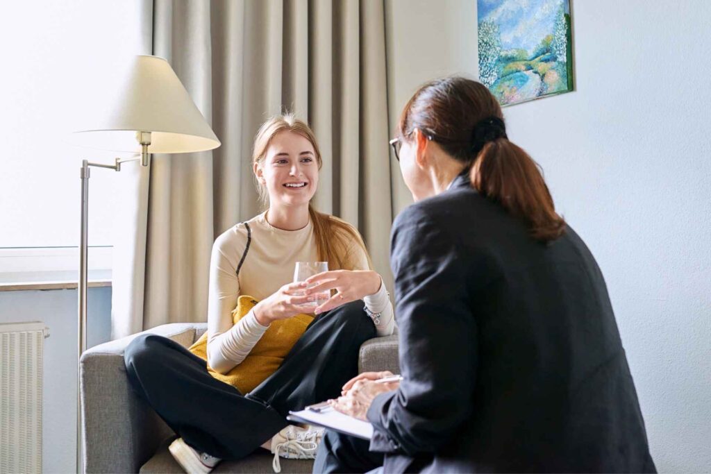 Woman having a supportive conversation with a professional about seeking help for addiction.